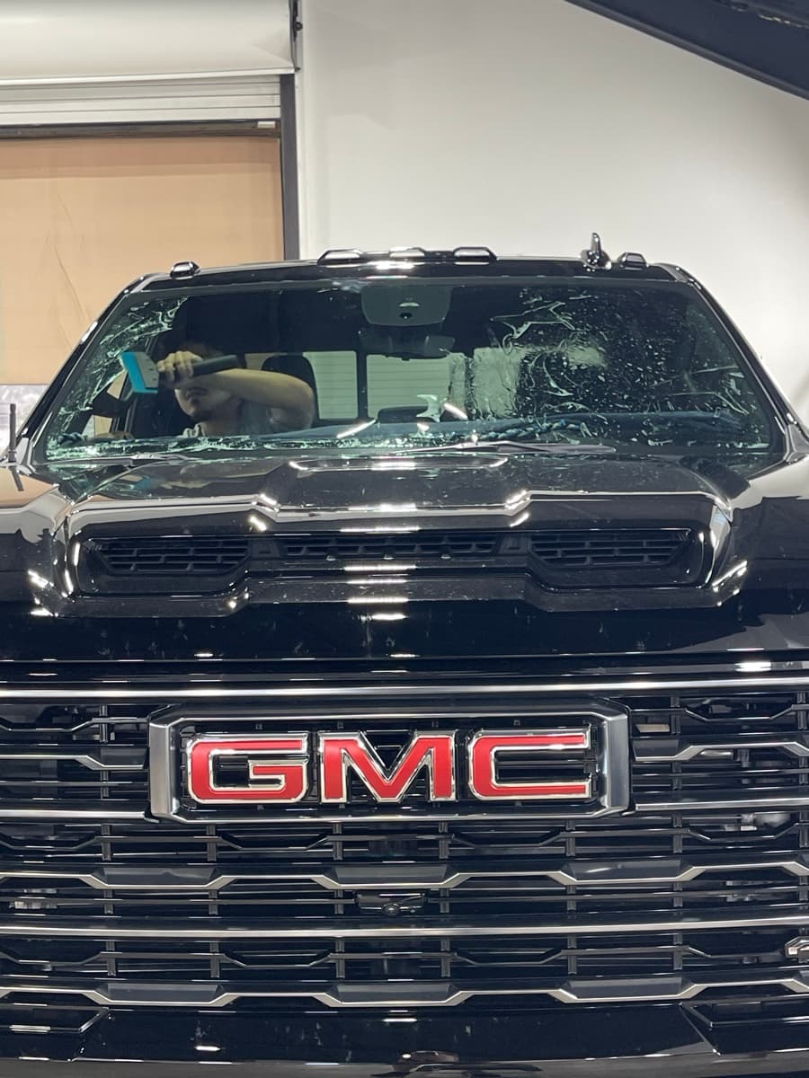 Professional window tinting action shot — technician applying tint film by Auto Trim Design