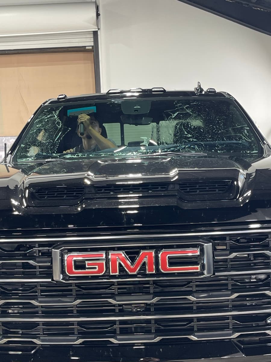 Professional window tinting action shot — technician applying tint film by Auto Trim Design