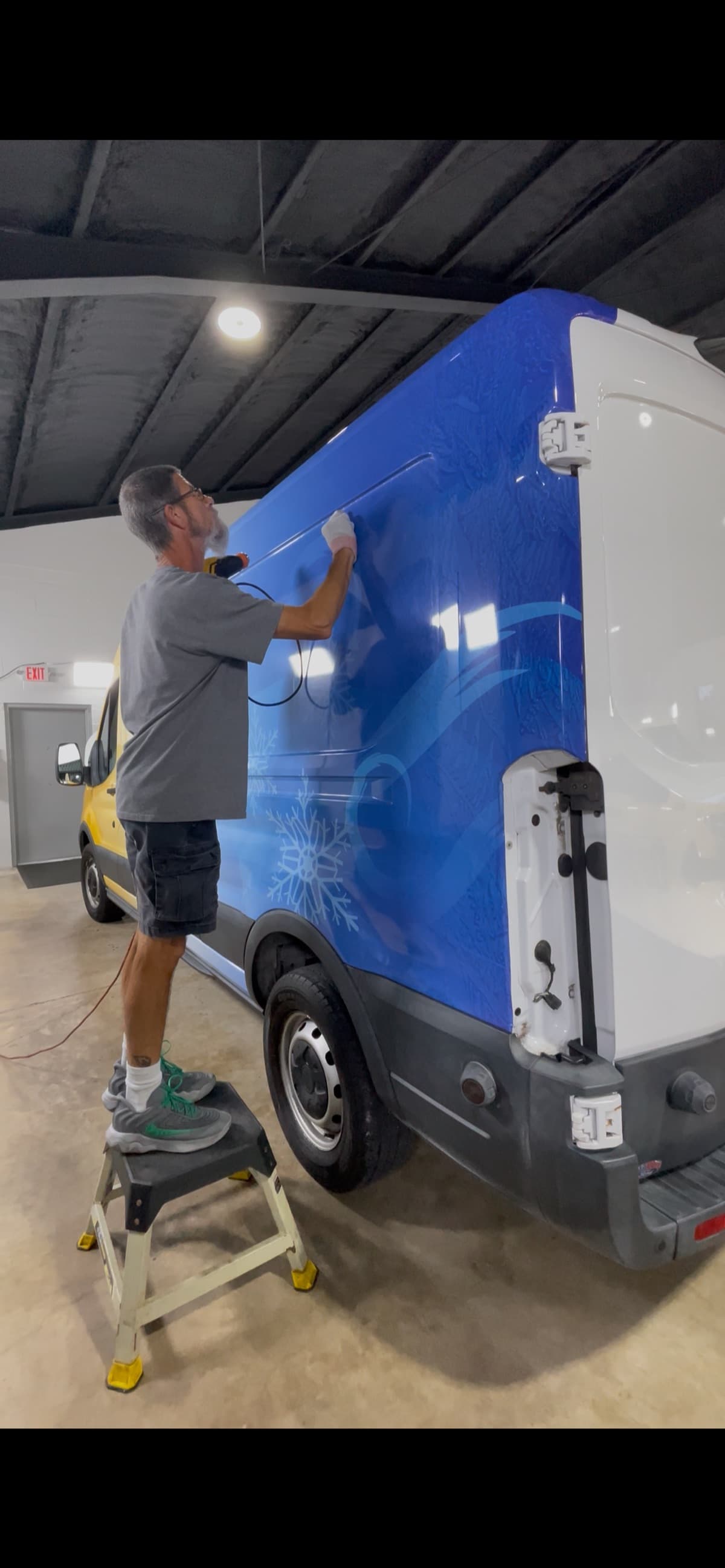 Vehicle wrap technician applying vinyl by Auto Trim Design Bradenton